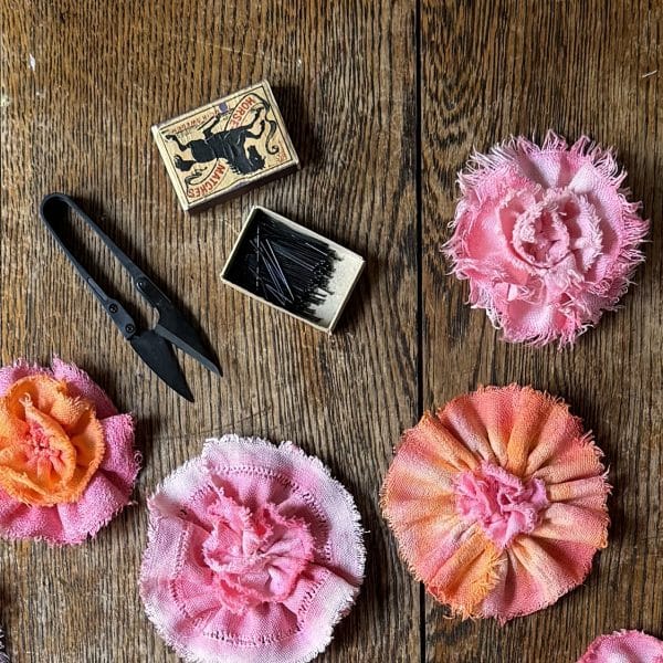 Handfärgade blomsterbroscher av vackra äldre textilier